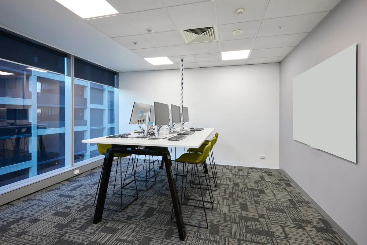 Collaboration meeting room with high table, monitors and whiteboard at the Navantia office fitout, Docklands.