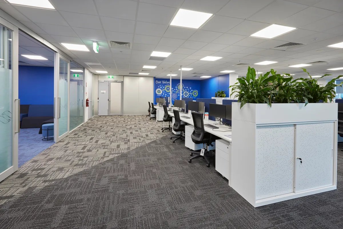 Open-plan workstations with planter screens and values wall at the Navantia office fitout, Docklands.