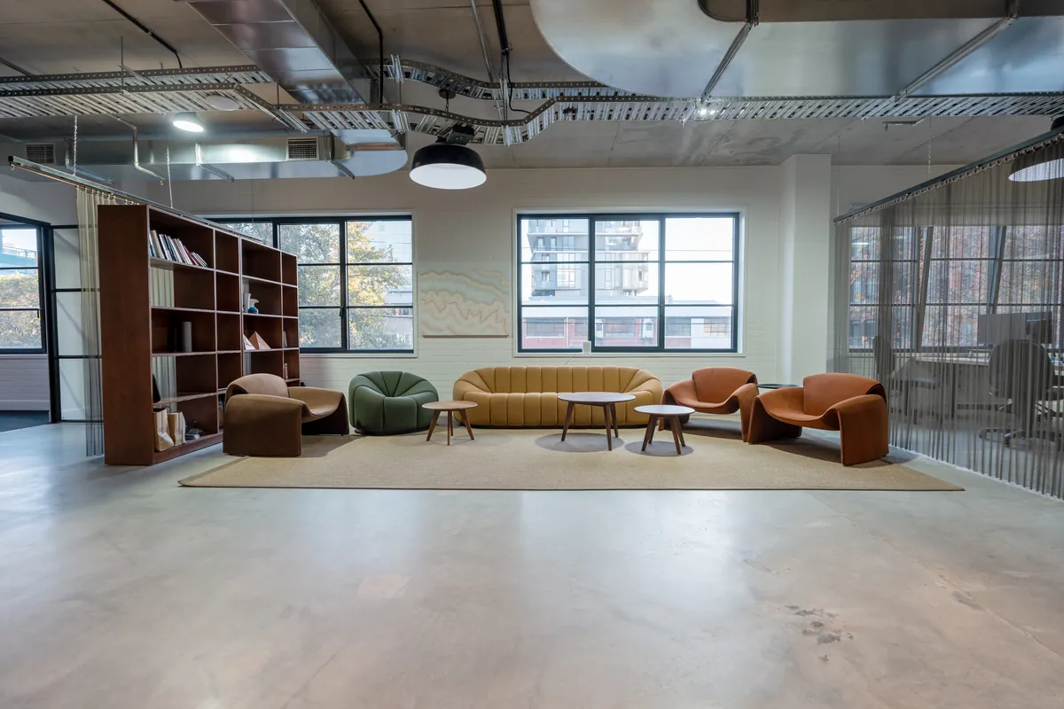 Breakout lounge with feature shelving and soft seating at the Resilience Project office fitout, Collingwood.