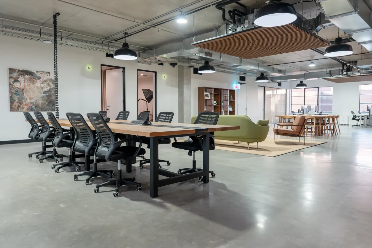 Open-plan workspace with collaborative table and workstations, Resilience Project office fitout, Collingwood.