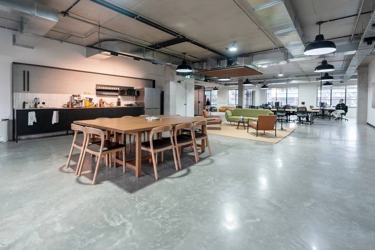 Open-plan area with communal dining table and breakout zone, Resilience Project office fitout, Collingwood.