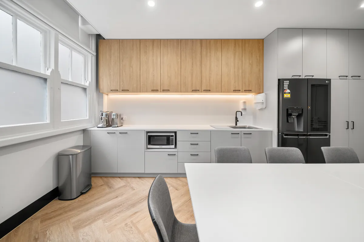 Staff kitchenette with timber cabinetry and dining table at the SleepWise Clinic dental clinic fitout, Melbourne.